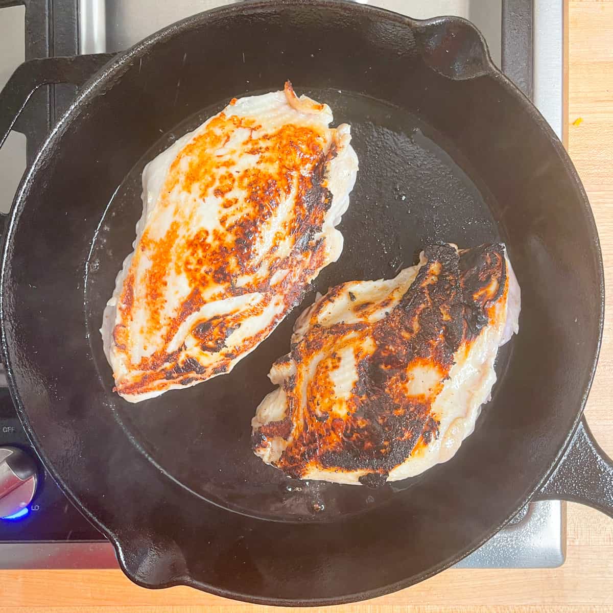 2 seared breasts in a cast iron skillet.