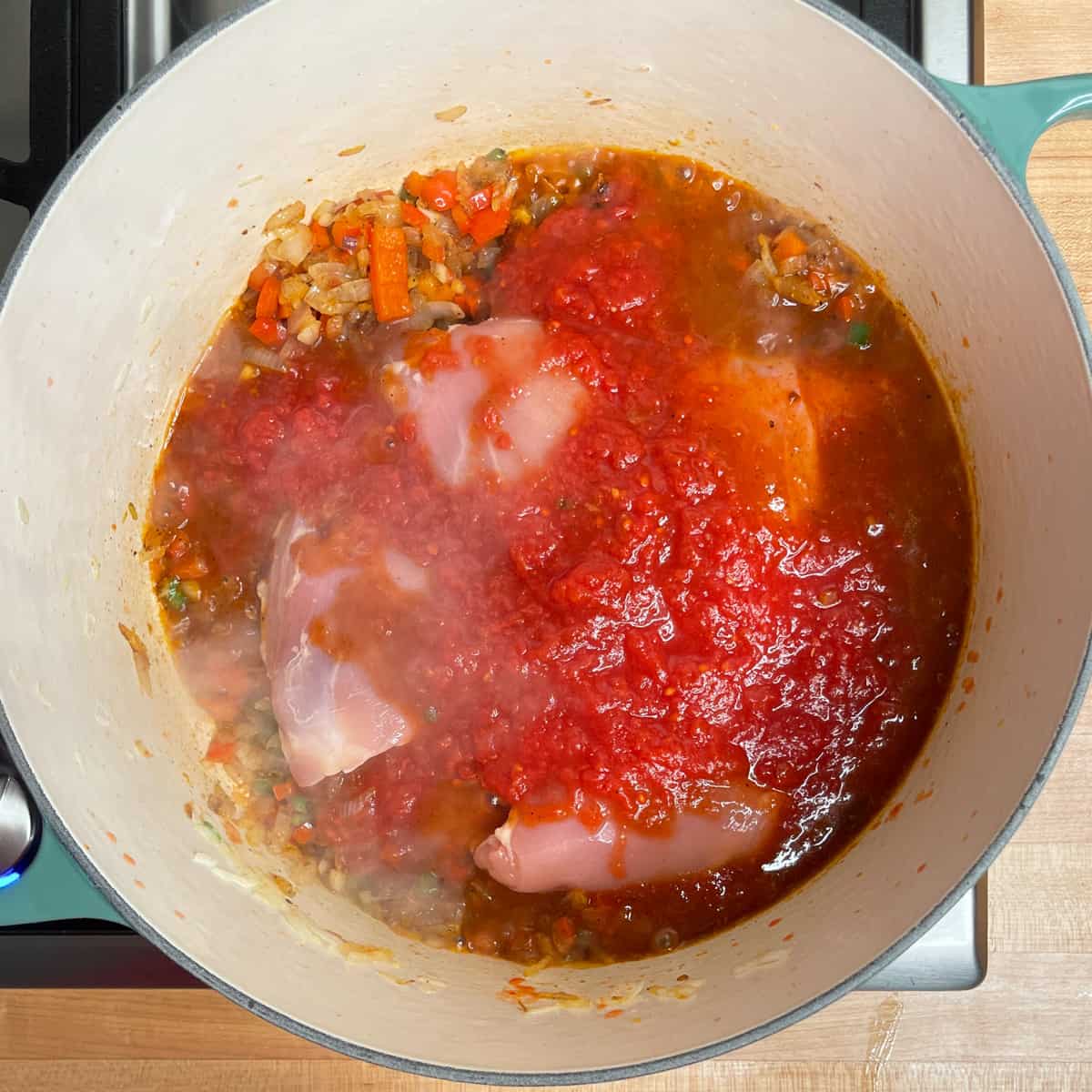 chicken and chopped tomatoes added to the pot.