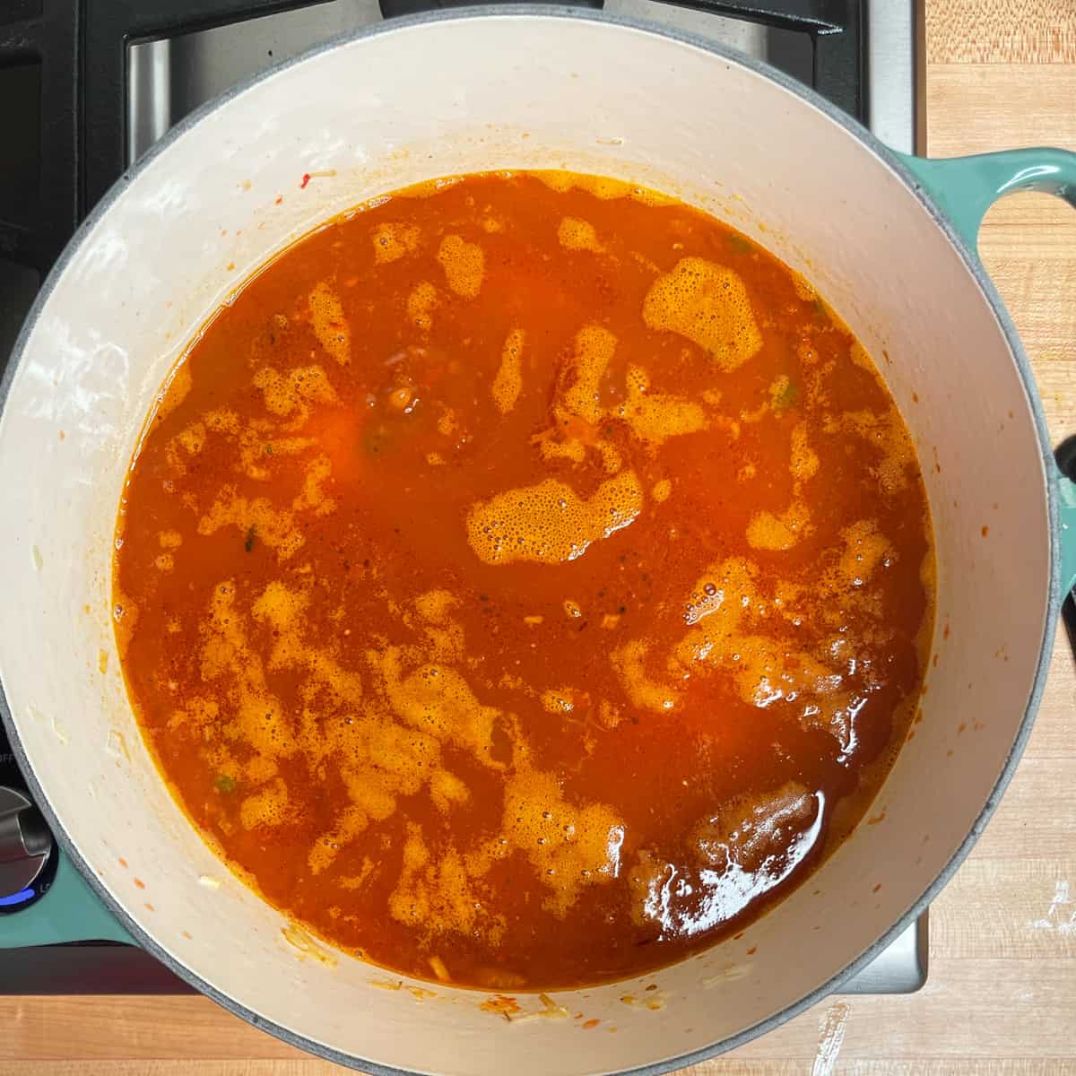 enchilada sauce and chicken broth have been added and liquid is starting to boil. 