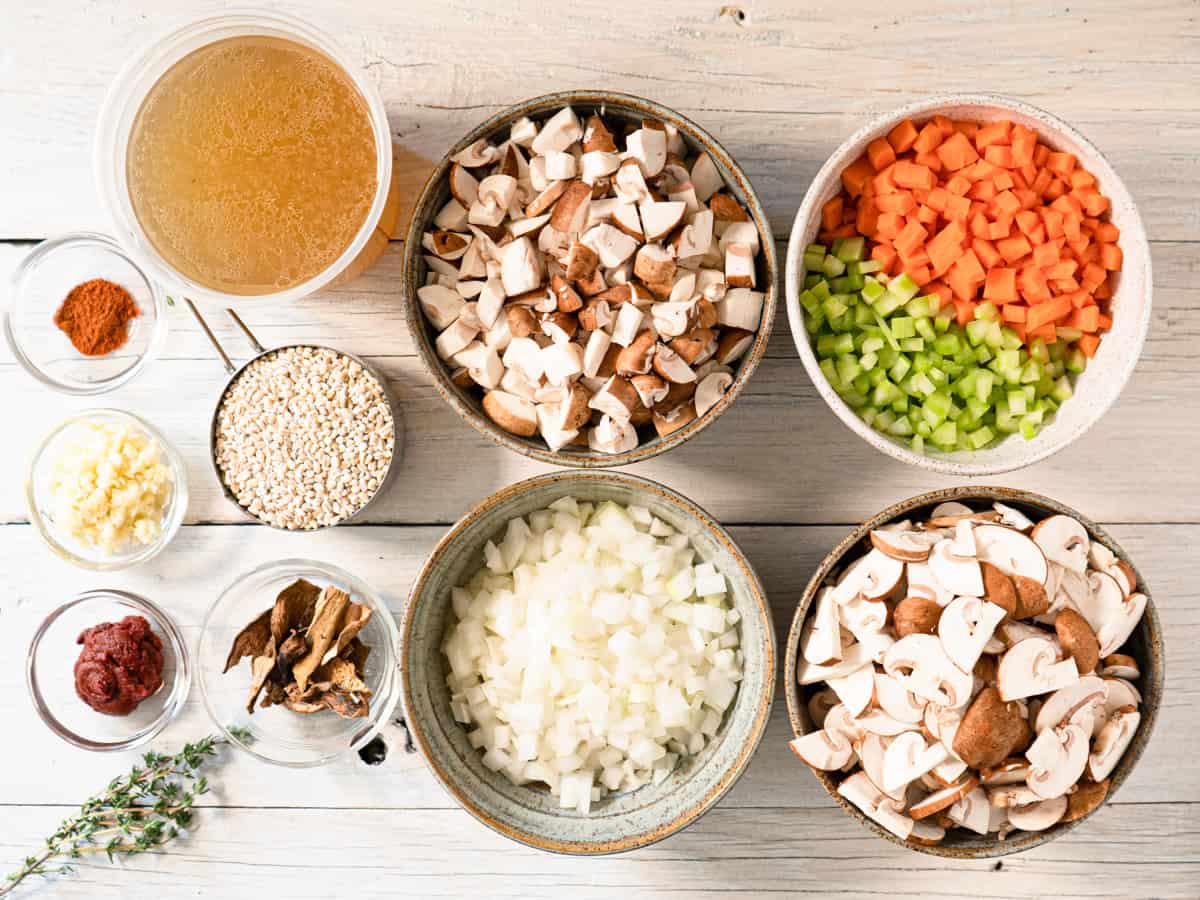 all ingredients to make the soup laid out on a white wood board.