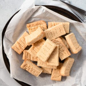 shortbread cookies in a pile on a parchment lined round tray.