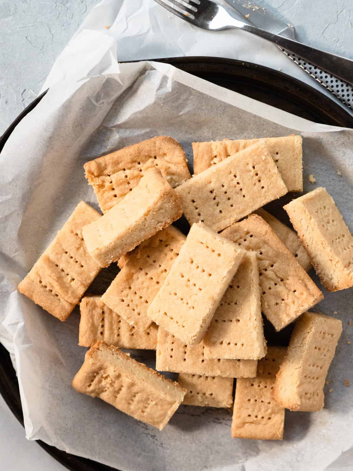 shortbread cookies in a pile on a parchment lined round tray.