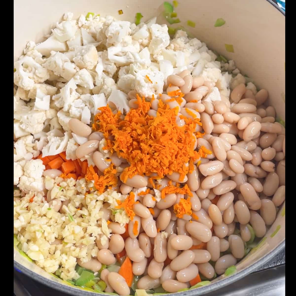 all vegetables, beans, turmeric and garlic are added to the pot.