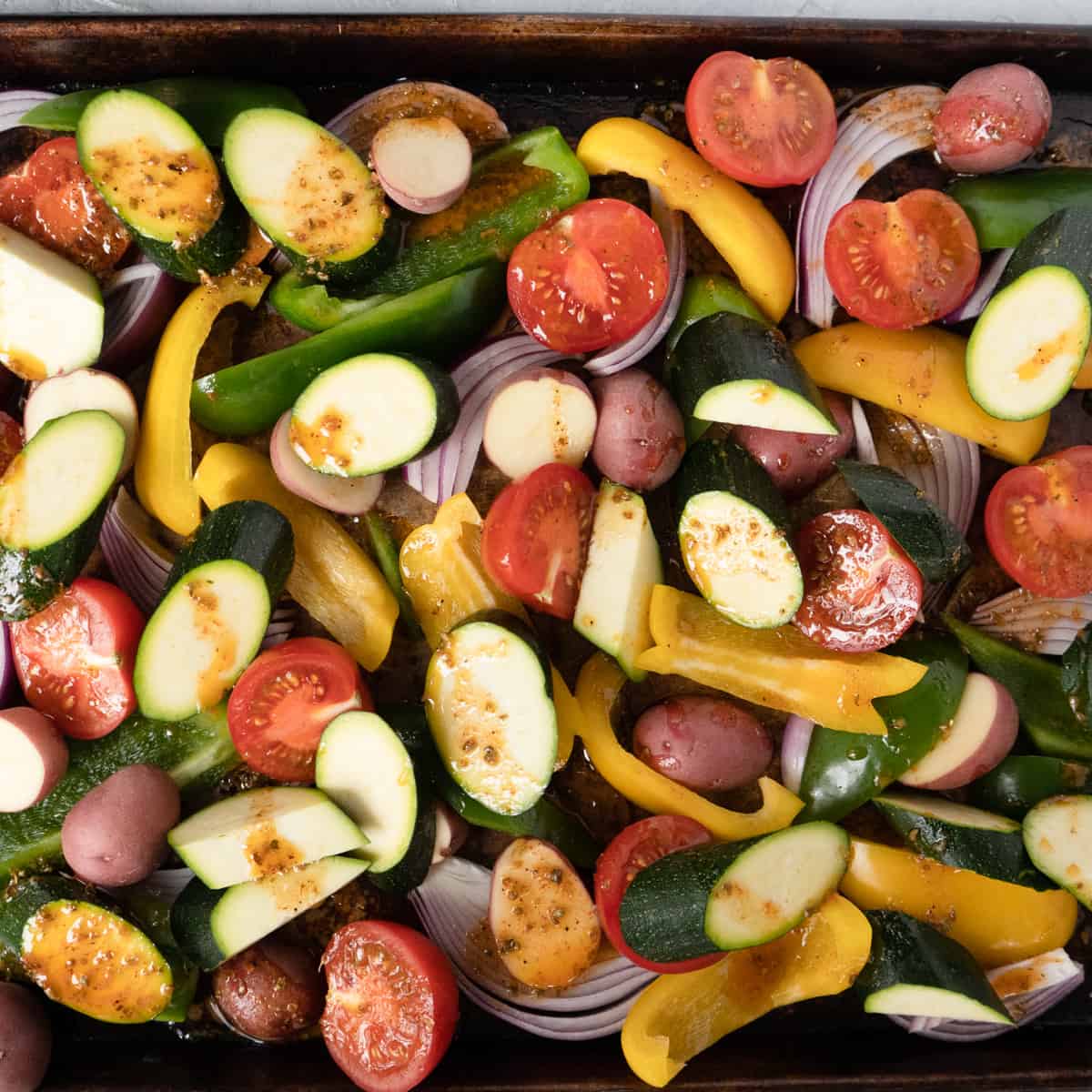 all the prepared vegetables on a baking tray, drizzled with remaining marinade.
