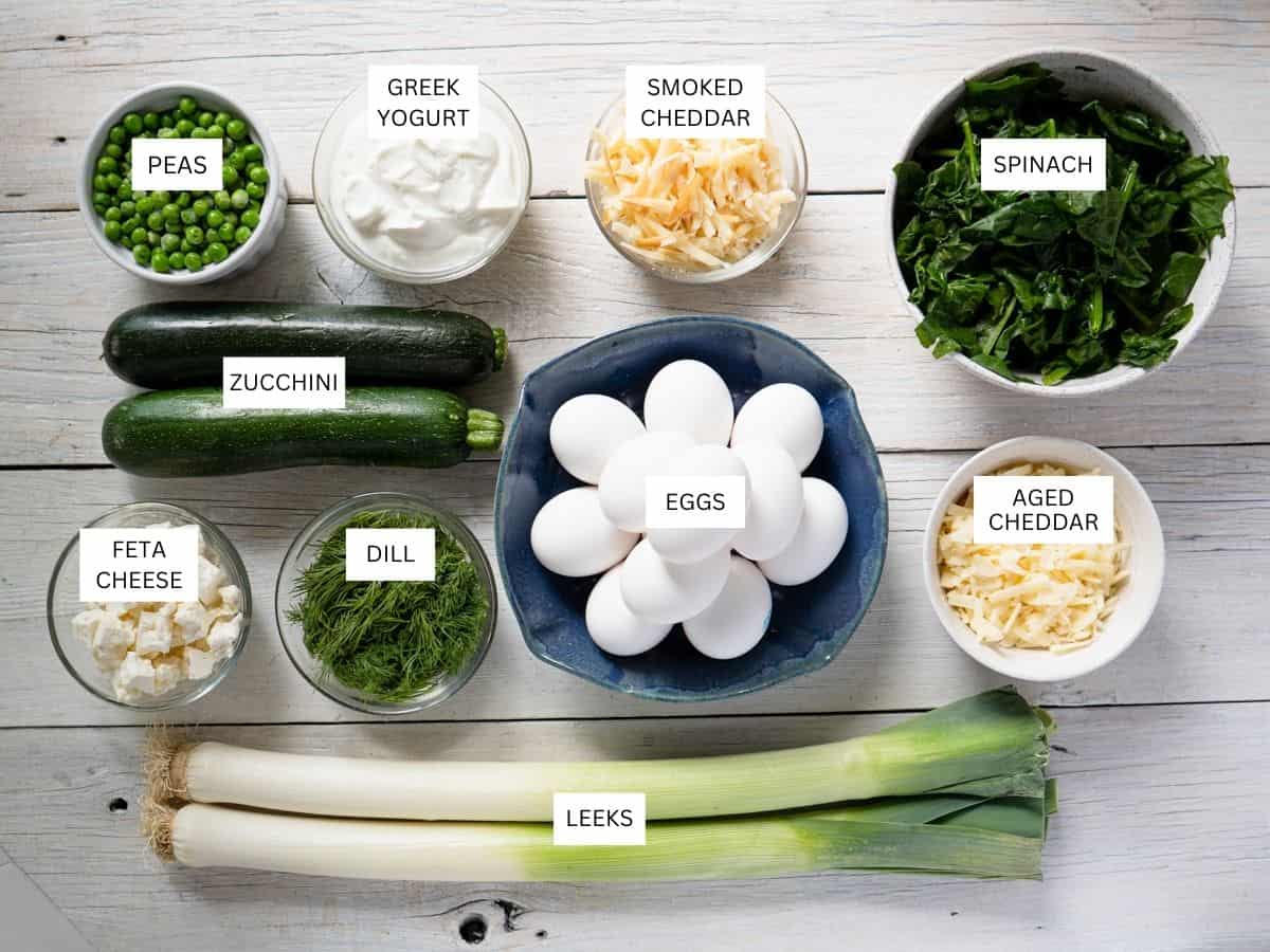 All ingredients needed to make this recipe in dishes, labeled and on a white wood background. 