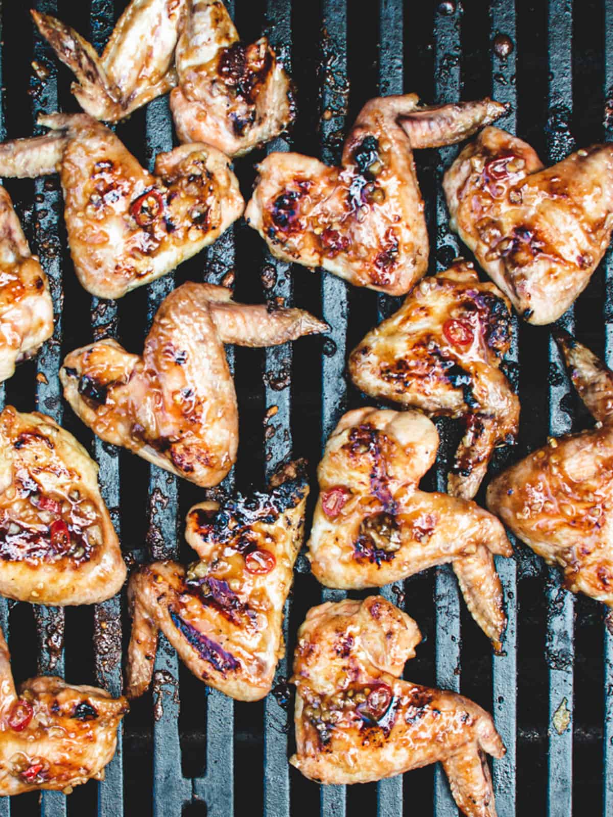 wings cooking on a grill with nice grill marks. 