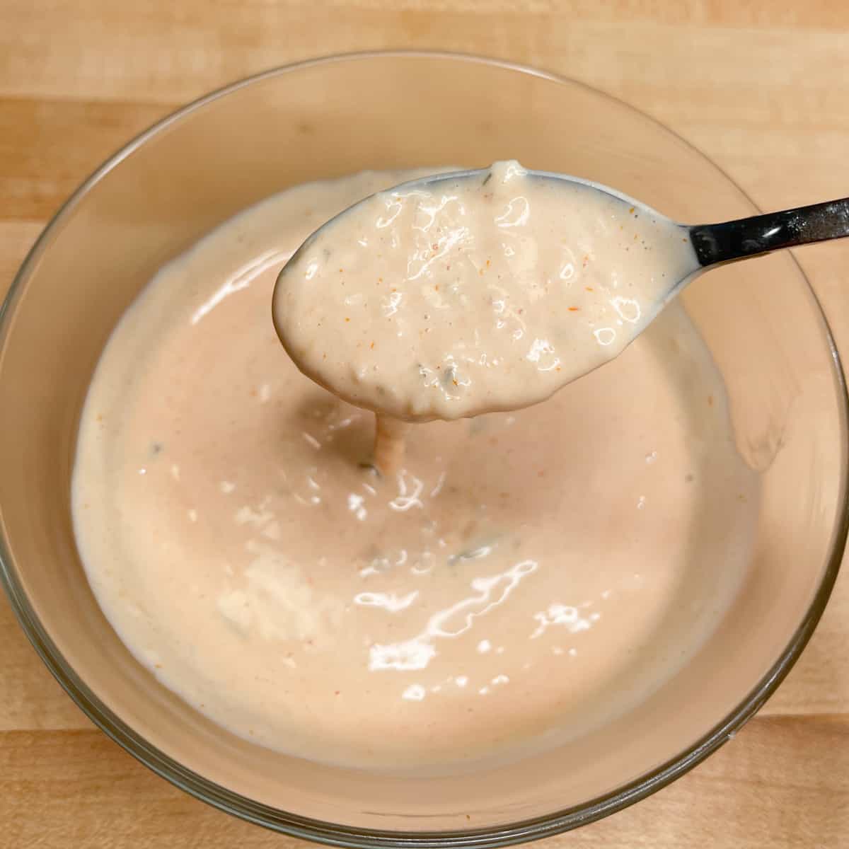Special sauce ingredients mixed together in a glass bowl with a spoonful showing. 