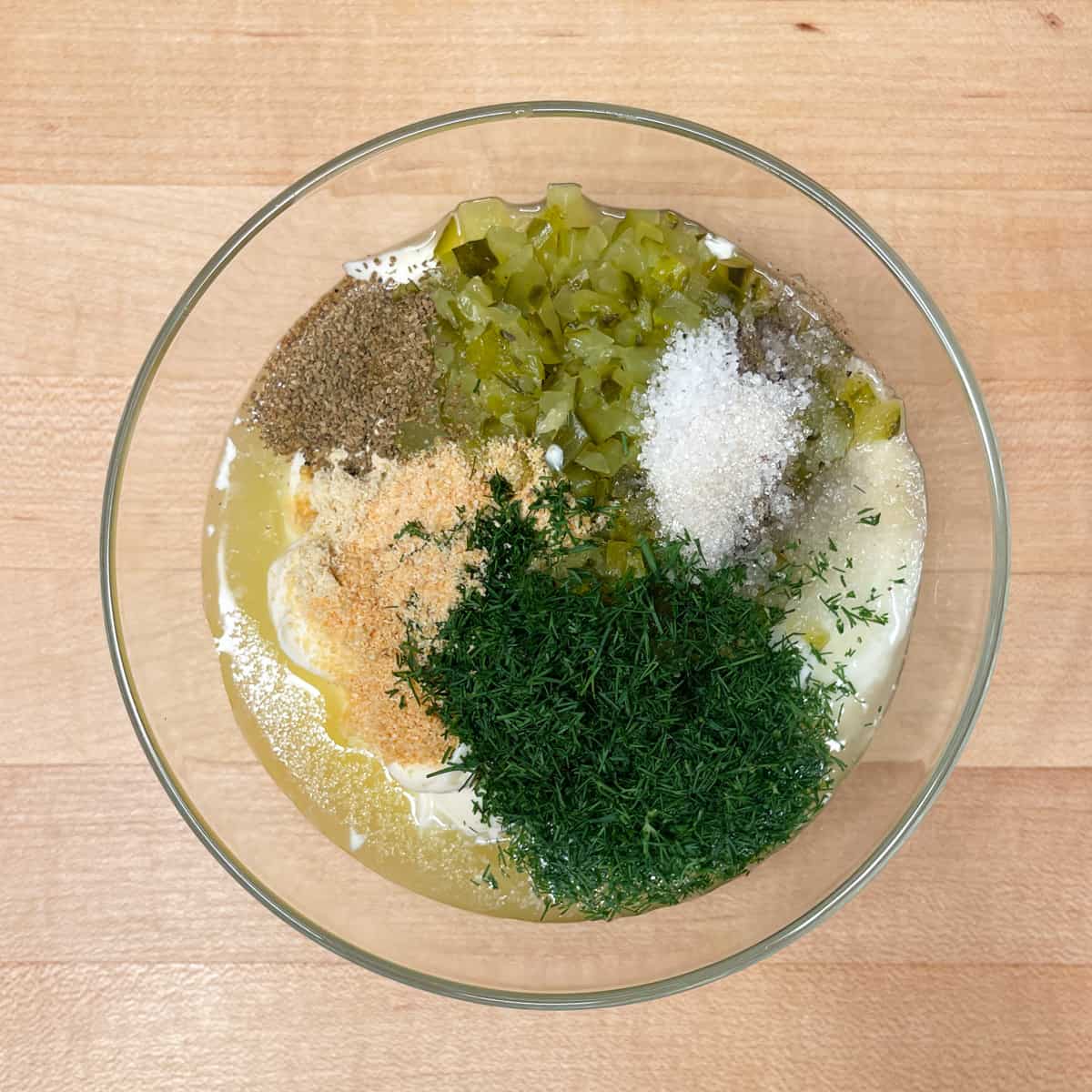 all ingredients for dill pickle dressing in a bowl before being mixed together. 