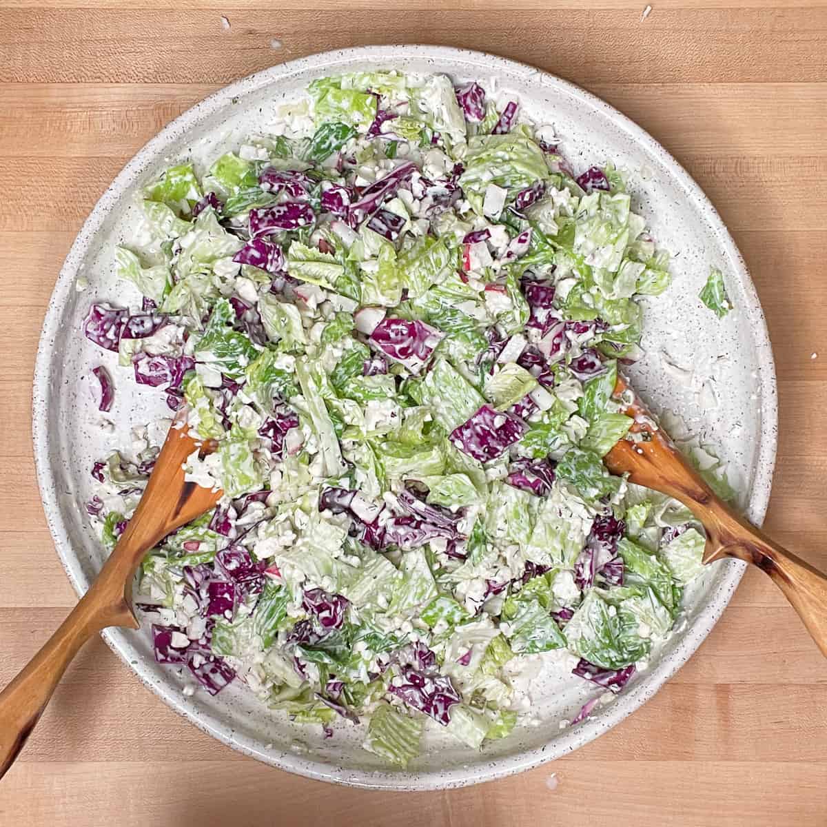 vegetables are mixed together with the dressing on a large white platter. 