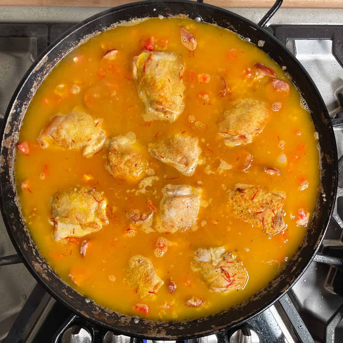 chicken in the paella pan with the rice and broth added. 