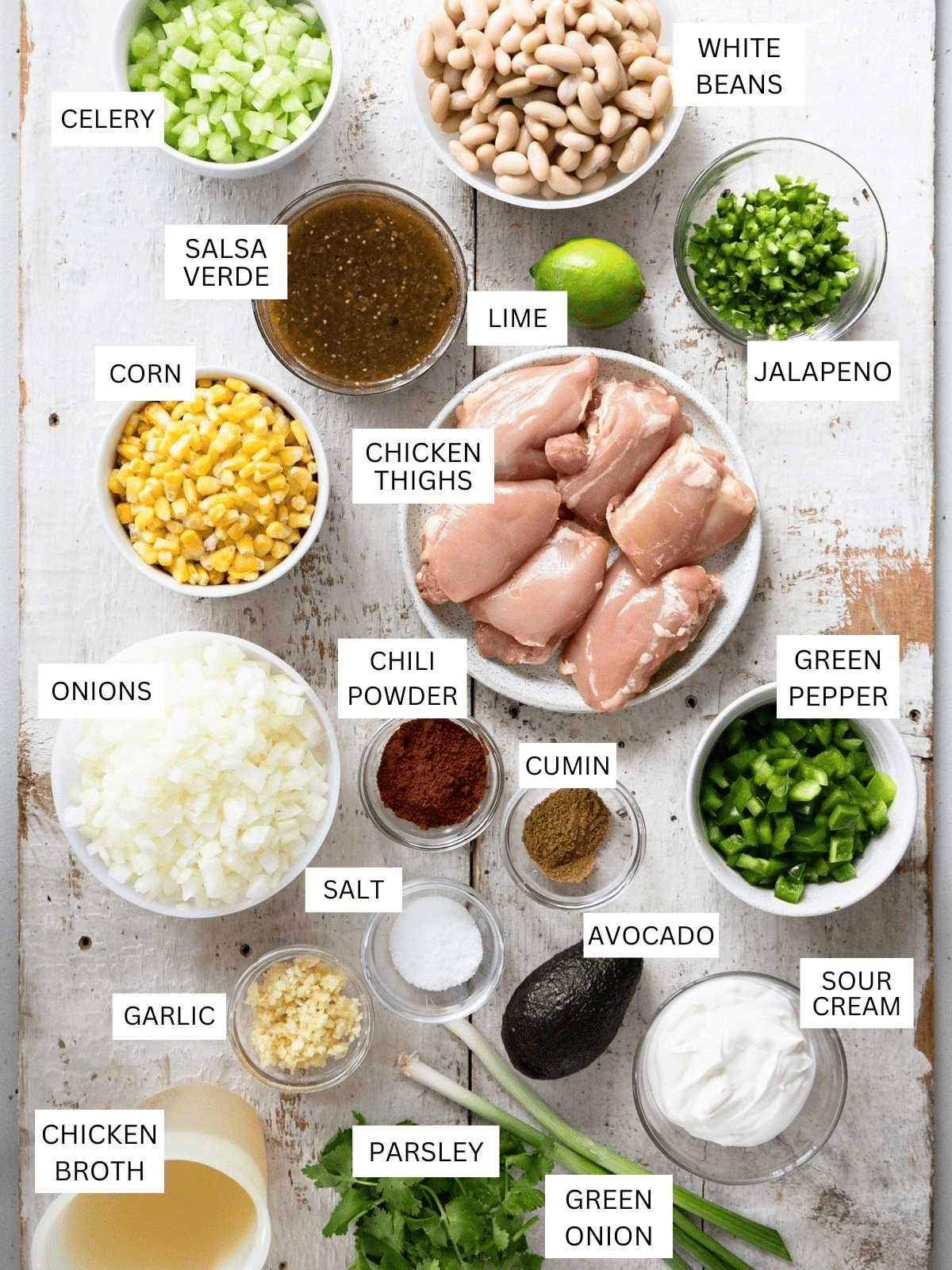 all ingredients you need to make green chicken chili laid out on a white background and labeled.