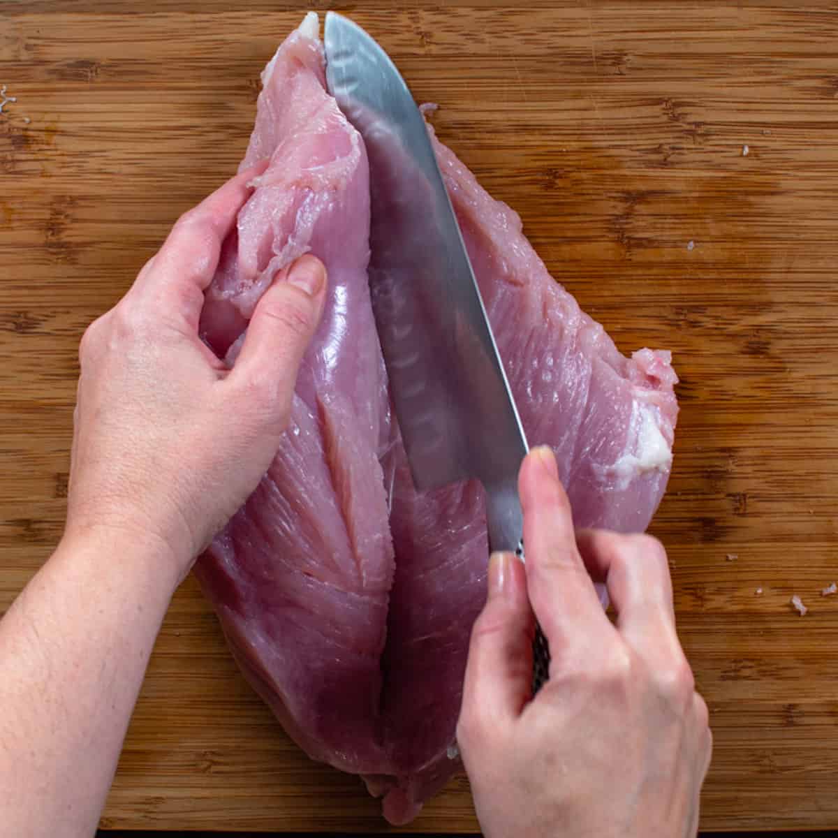 cutting a turkey breast in half to open like a book. 