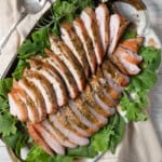 2 smoked turkey breasts thinly sliced on a bed of lettuce.