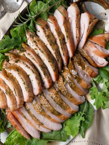 2 smoked turkey breasts thinly sliced on a bed of lettuce.