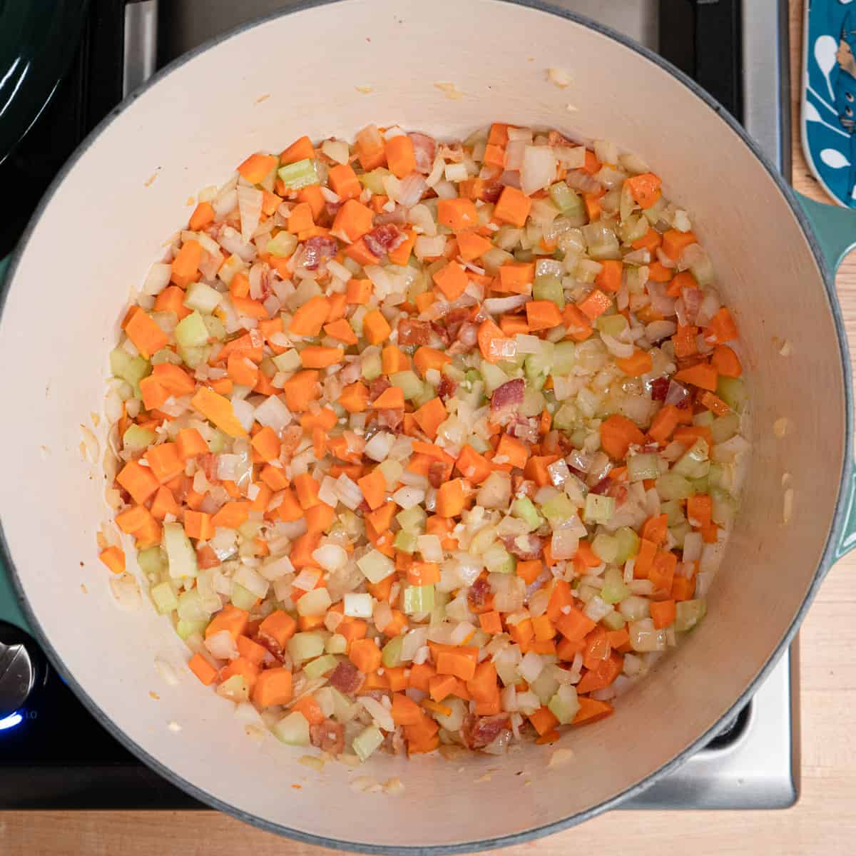 celery, carrot, onions and bacon frying in a large soup pot. 
