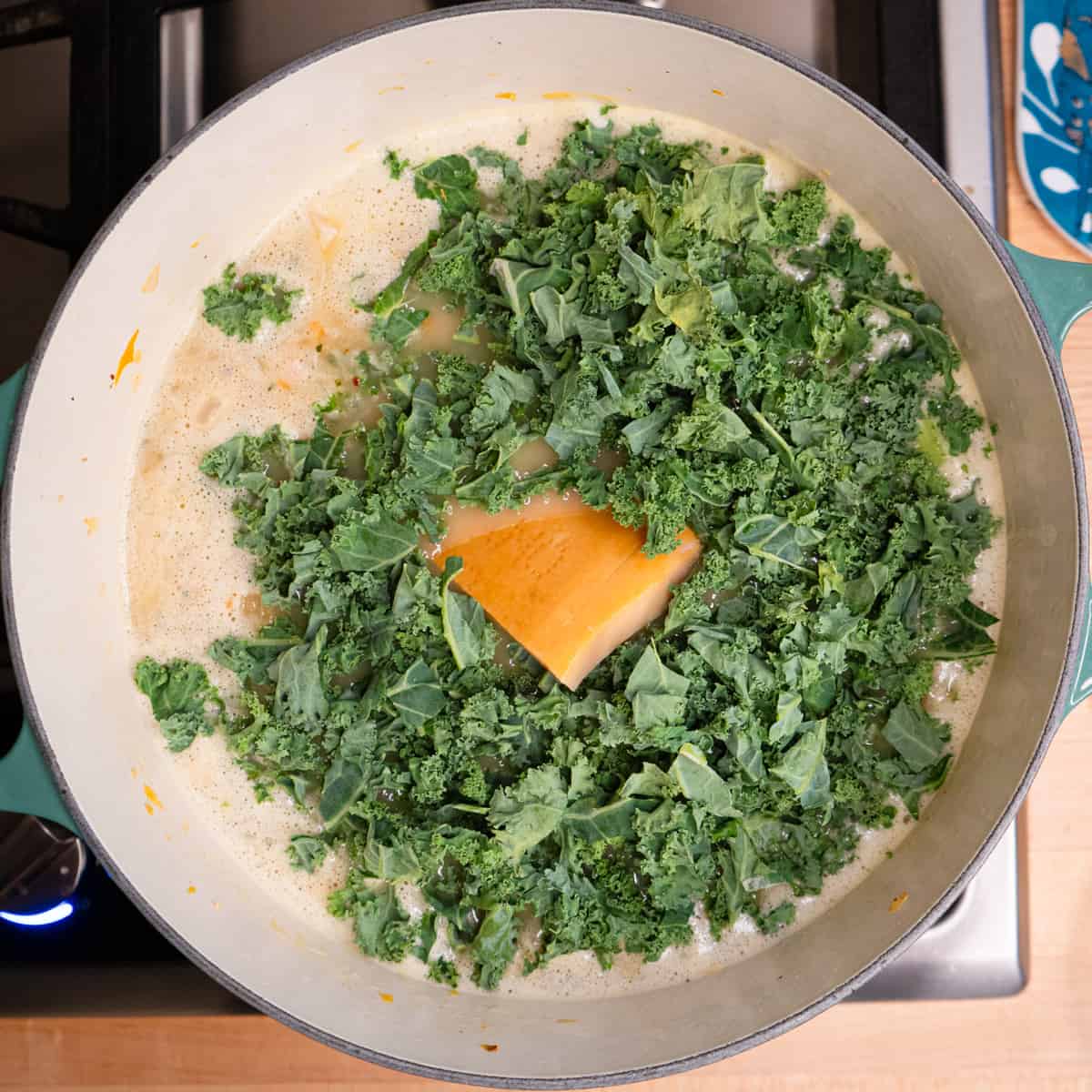 kale and Parmesan rind are added to the soup pot with the other ingredients. 