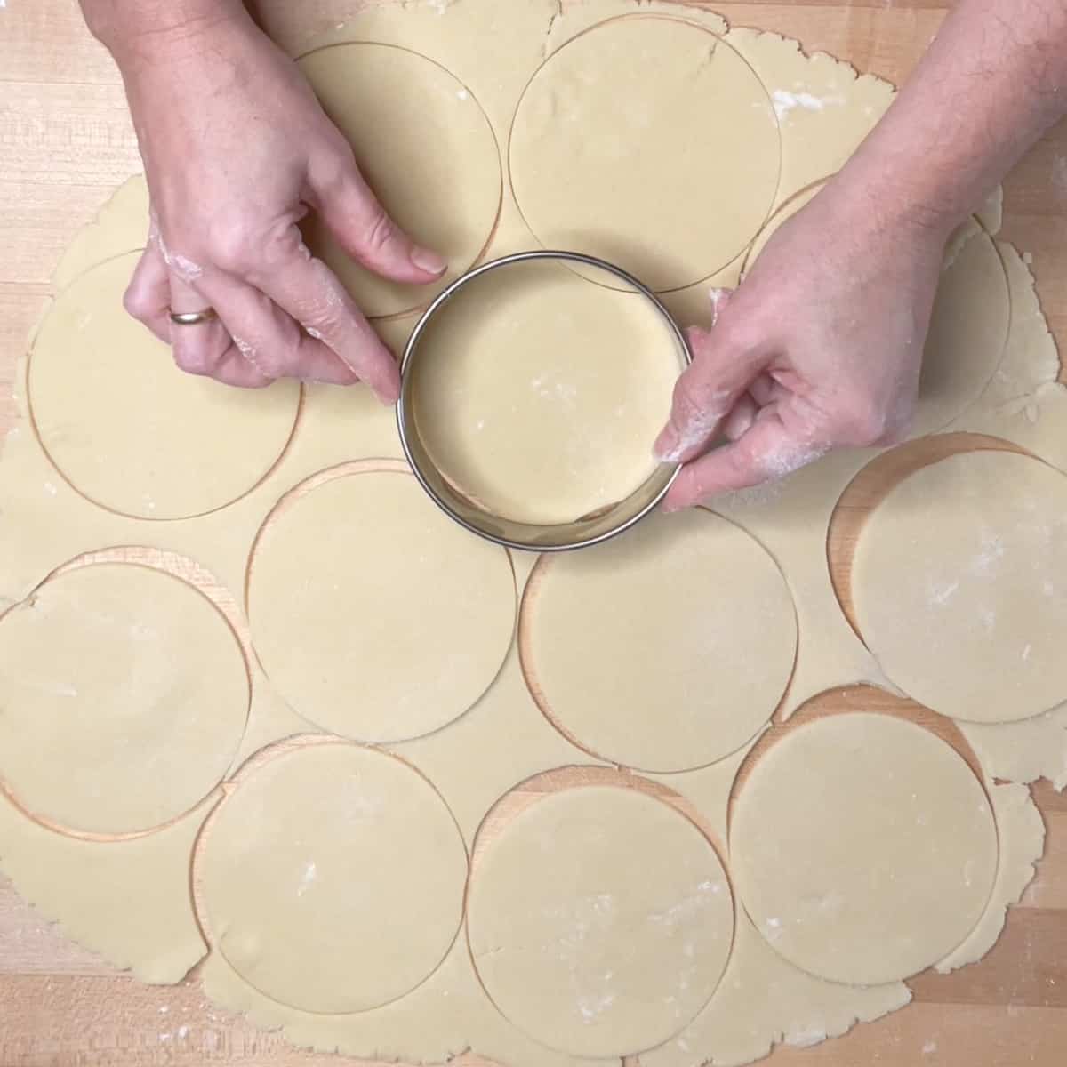 pastry is rolled out and being cut into circles.