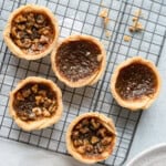5 butter tarts on a wire cooling rack.
