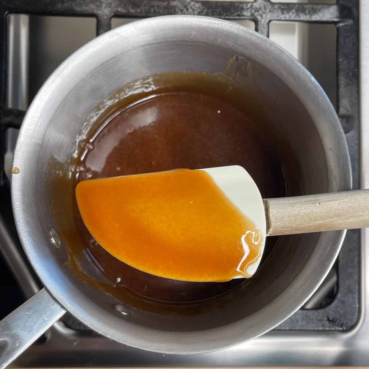 a rubber spatula showing that sugar has been dissolved in butter tart filling.