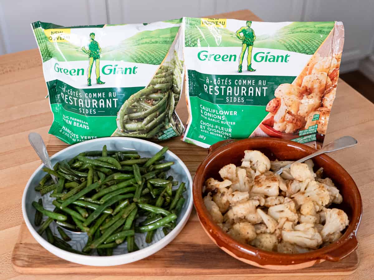 green beans and cauliflower side dishes in serving dishes along with their packaging. 