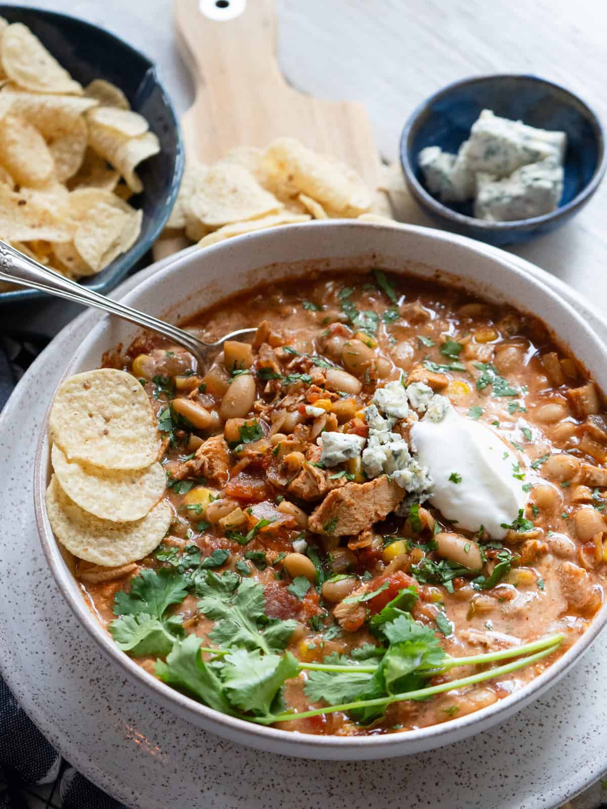 slow cooker buffalo chicken chili in bowl with toppings.