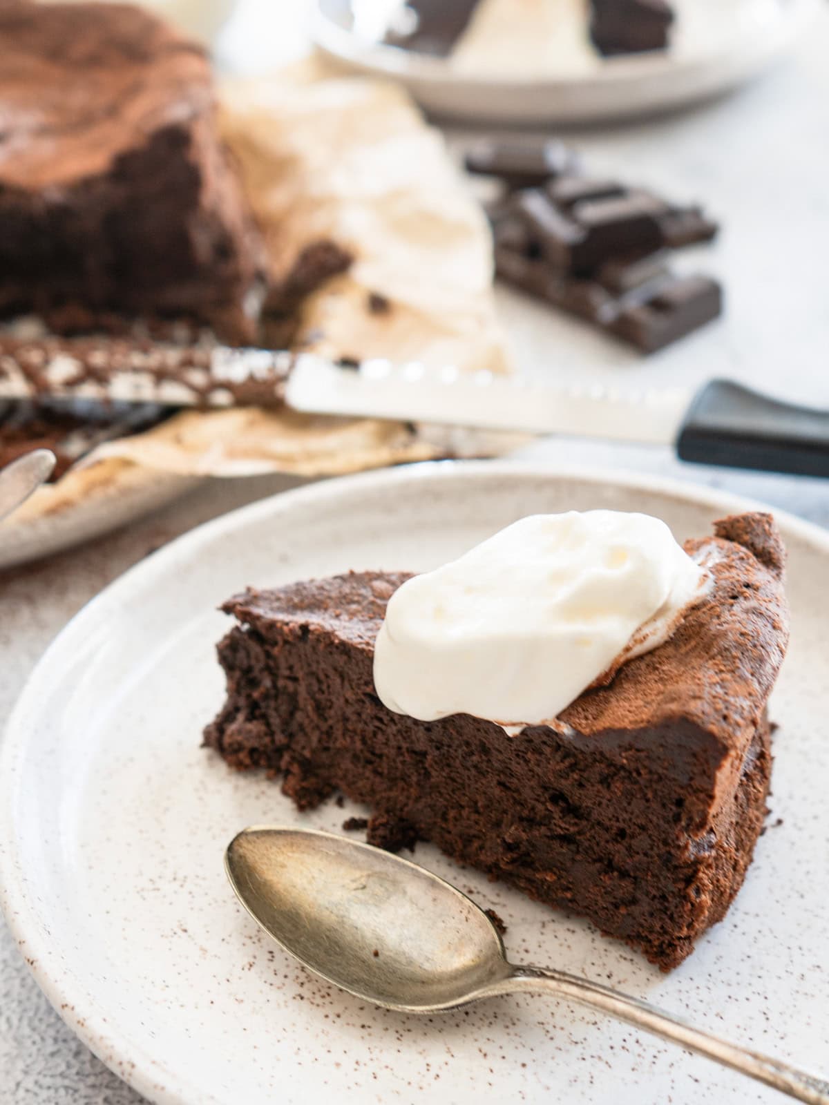 One slice of chocolate souffle cake topped with cream.