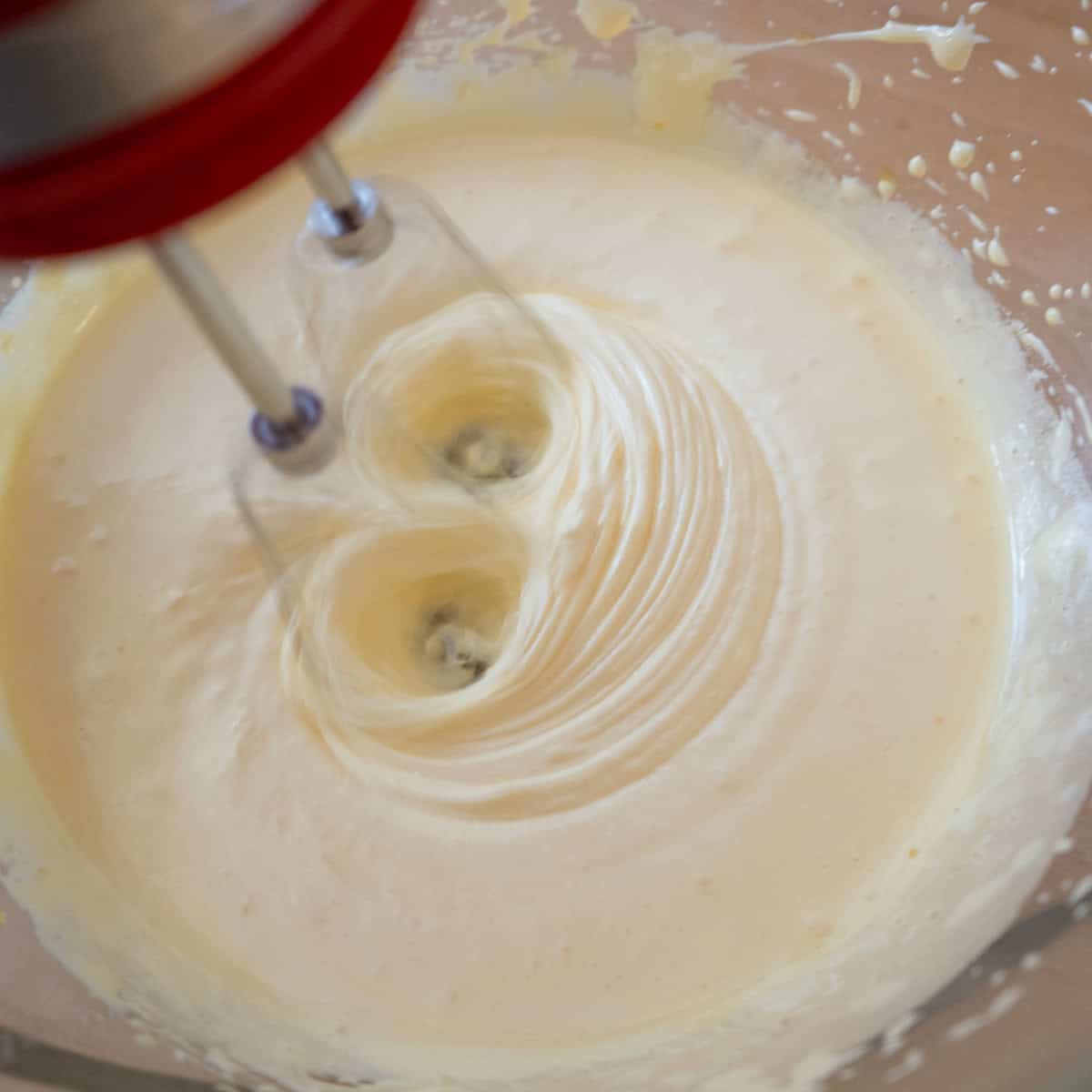 Egg yolks being whipped until light yellow and fluffy.