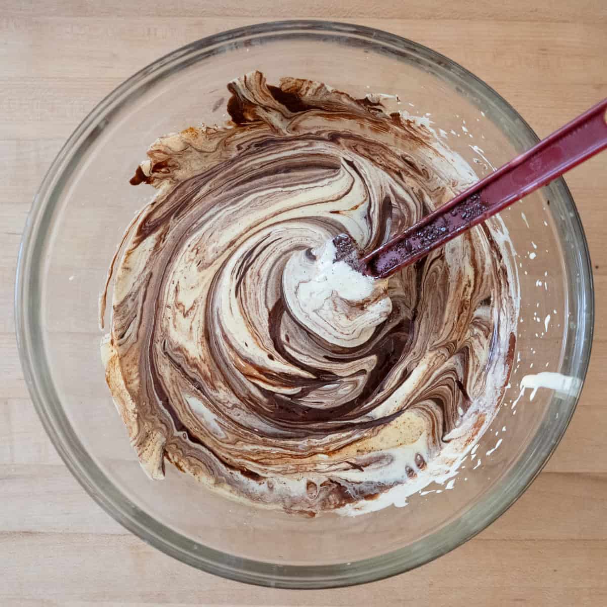 Egg yolks partially folded into melted chocolate and butter mixture.