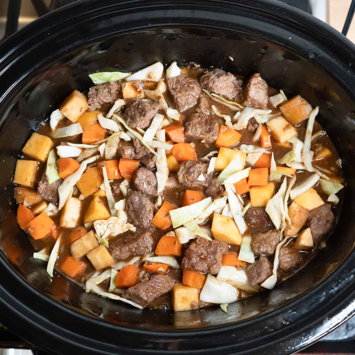 Cabbage added to a slow cooker beef and guinness stew.