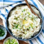 Potato turnip mash in a serving dish with a wooden spoon.