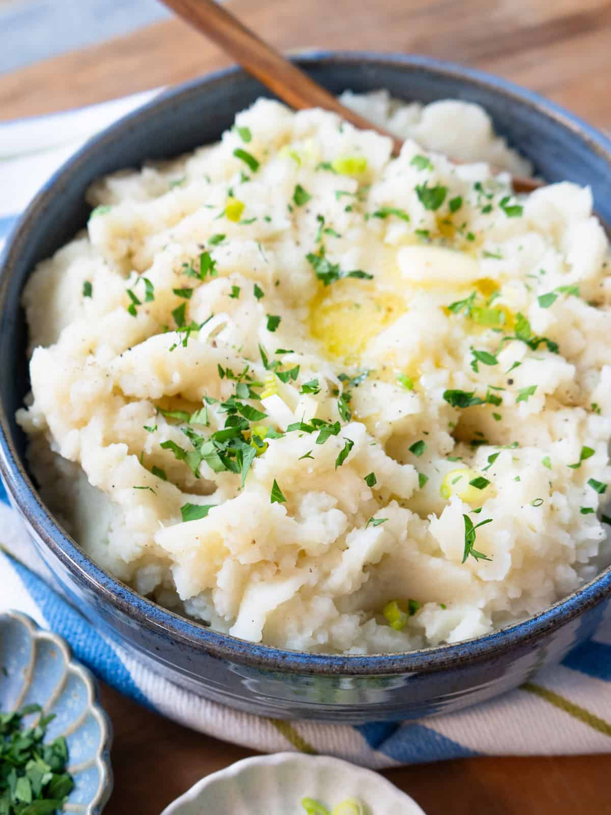 Potato and turnip mash in a serving dish with a pat of butter melting on top.