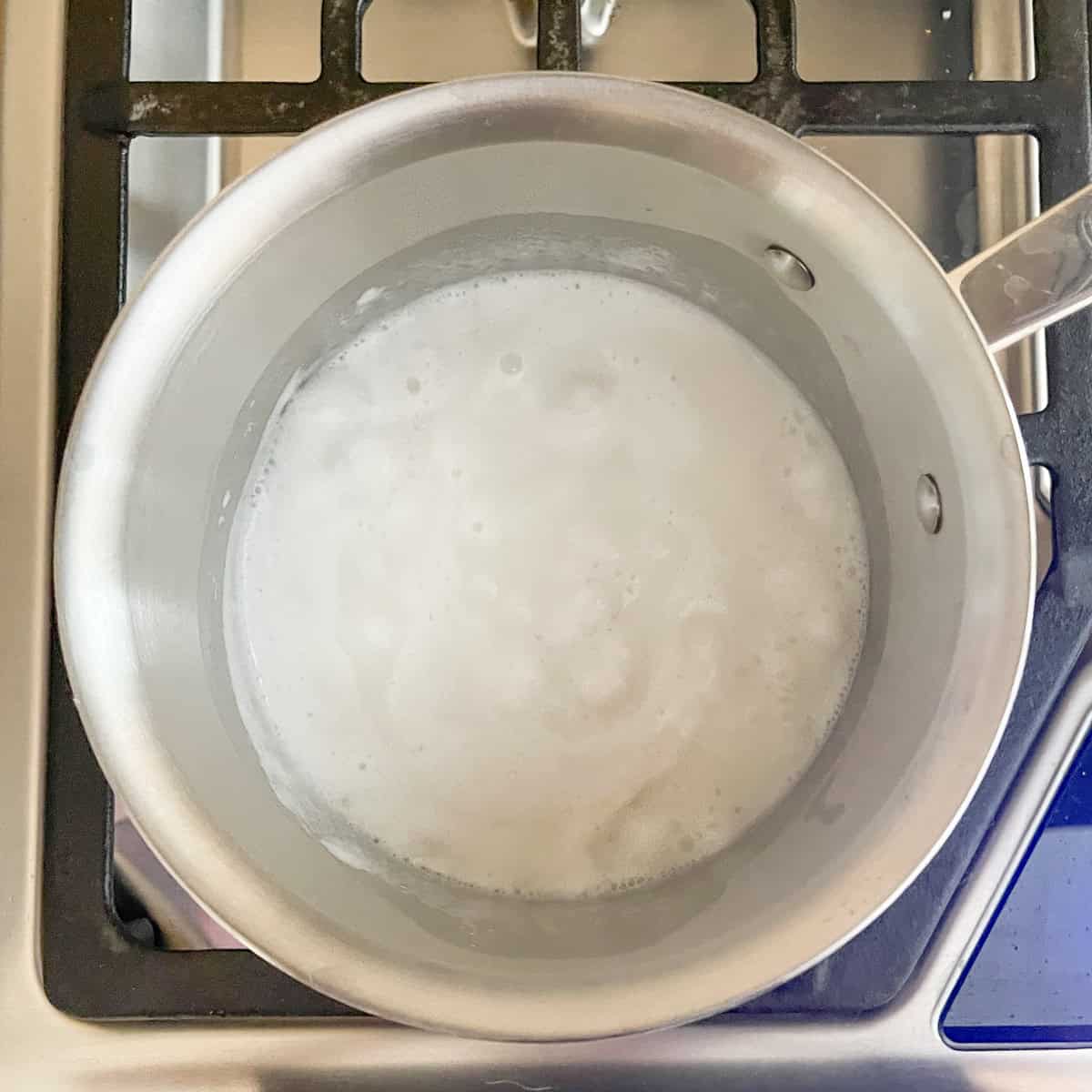 Rice, water and coconut milk boiling in a pot.