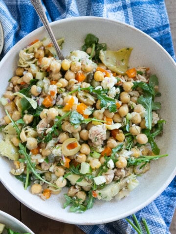 One serving of chickpea and tuna salad sitting on a blue towel.